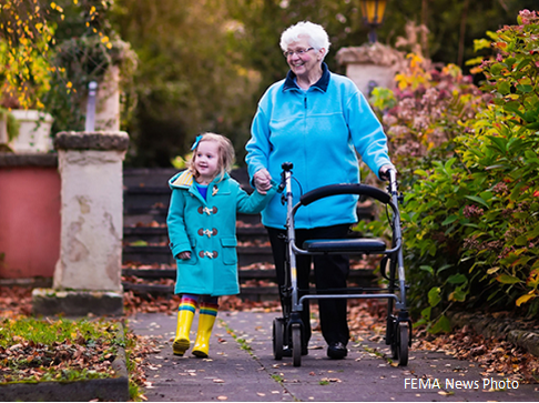 Picture of senior woman with a walking holding hands with a young girl