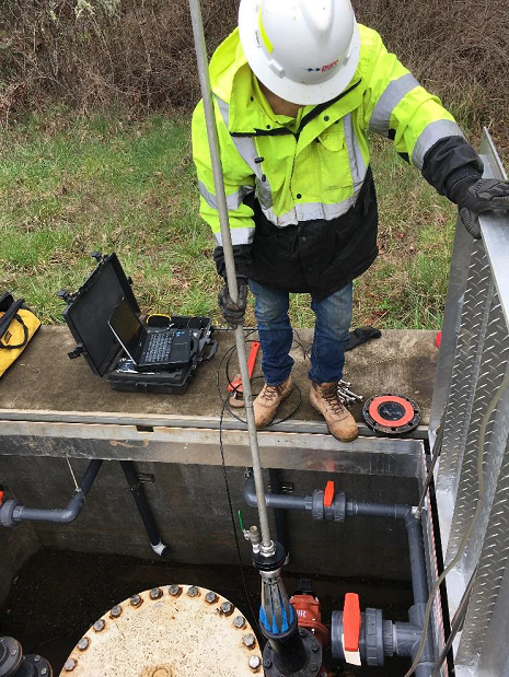 Worker inserts an acoustic sensor into an EWEB water main
